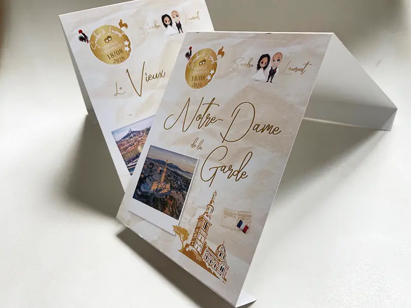 Deux noms de table de mariage marseillais posés sur un chevalet : le Vieux-Port et la Bonne Mère (Notre-Dame de la Garde)