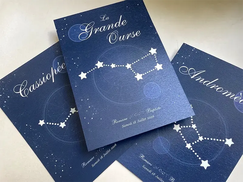 cartes de noms de table constellations étalées sur une table.