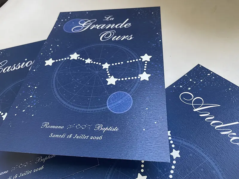 cartes de noms de table constellations étalées sur une table.